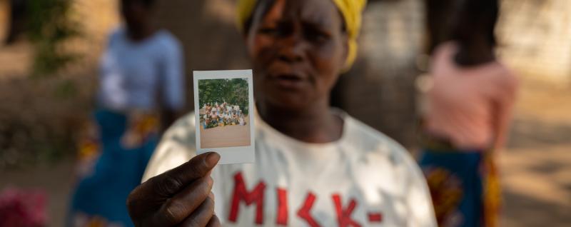 Pigeon pea farmer, Esther, holding a polaroid.