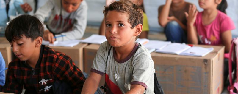 Children in Gaza using cardboard boxes in classes to learn