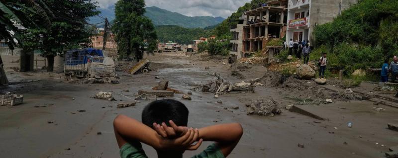 A boy looks at the devastation caused by flash flooding along the Trishuli River in Nepal's Nuwakot district, Wednesday, Aug. 26, 2026