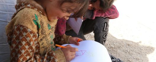 Six-year old Sara (not her real name) drawing outside her tent. She has been living in a tent in a collective shelter since the earthquake damaged her home in rural Aleppo, in northwest Syria.