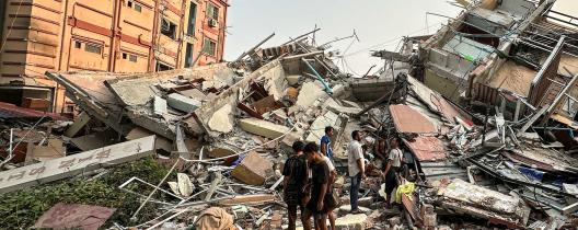 People stand past the debris of a collapsed building in Mandalay, Myanmar, on 28 March 2025 after the earthquake. Photo: Sai Aung Main/AFP/Getty.